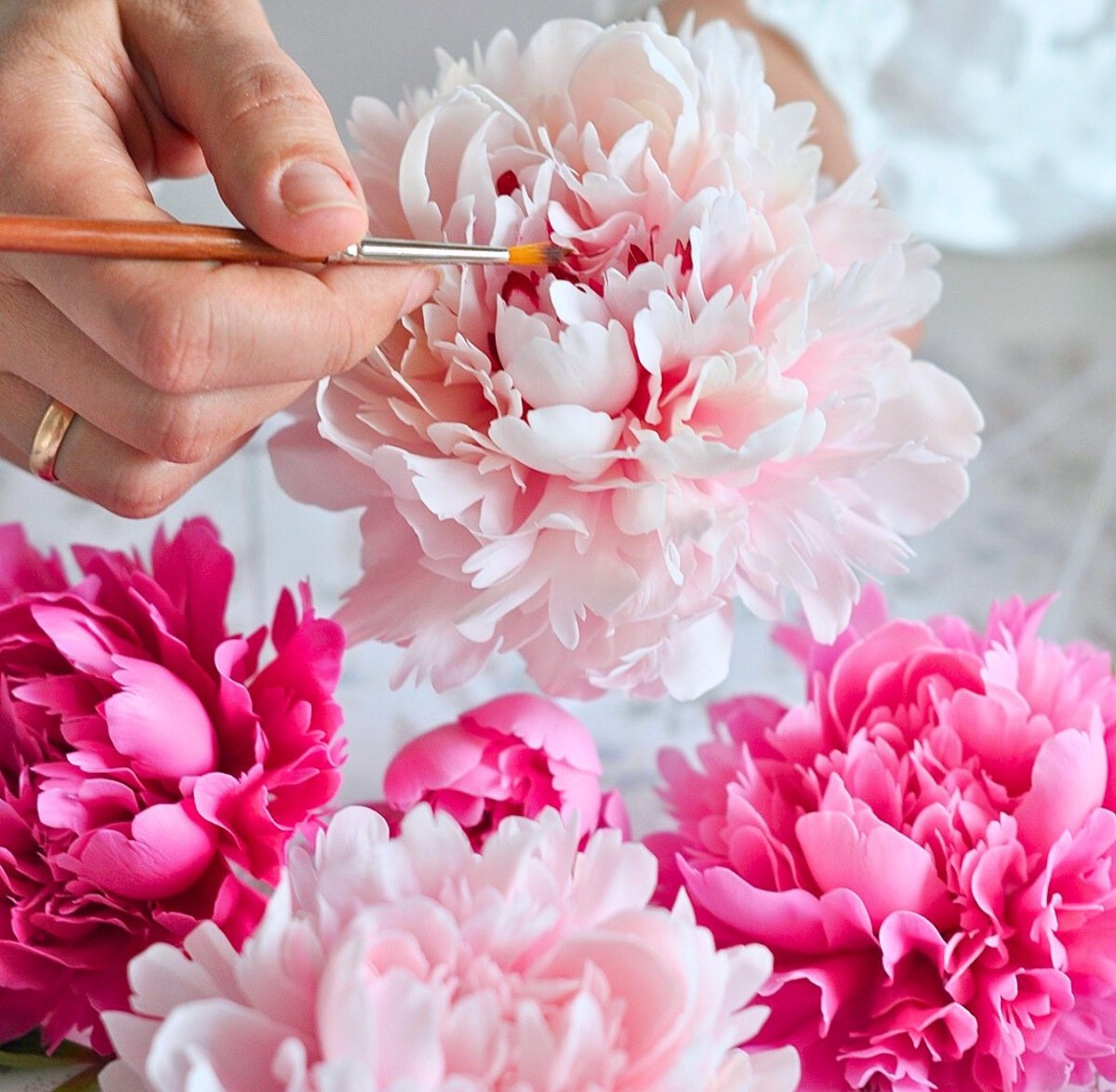 Careful painting of clay flower figures