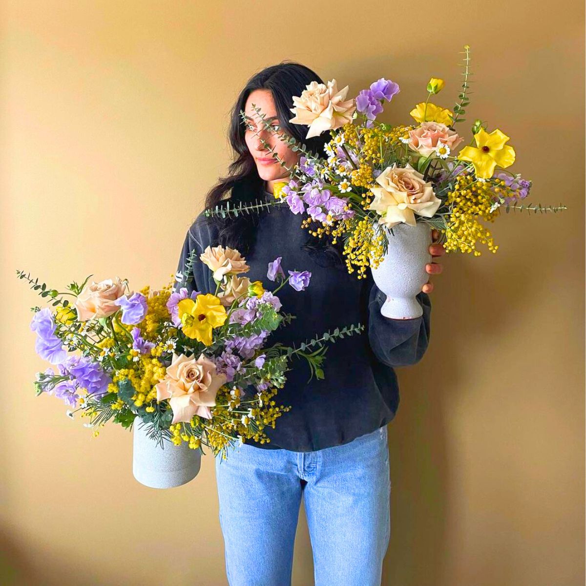 Tricia DiMarco with yellow and purple arrangements