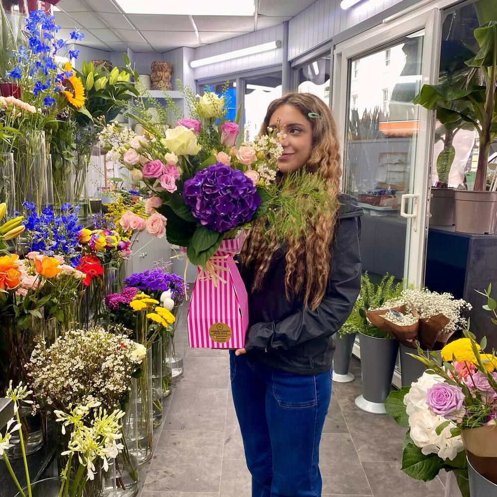 lady maintain flower in shop 