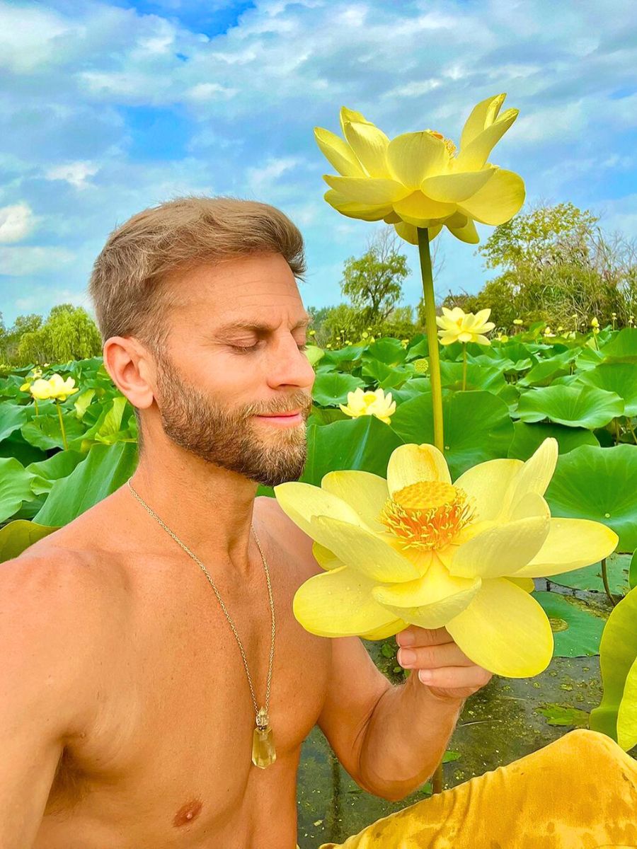 A guy in between waters with flourished yellow lotus flowers