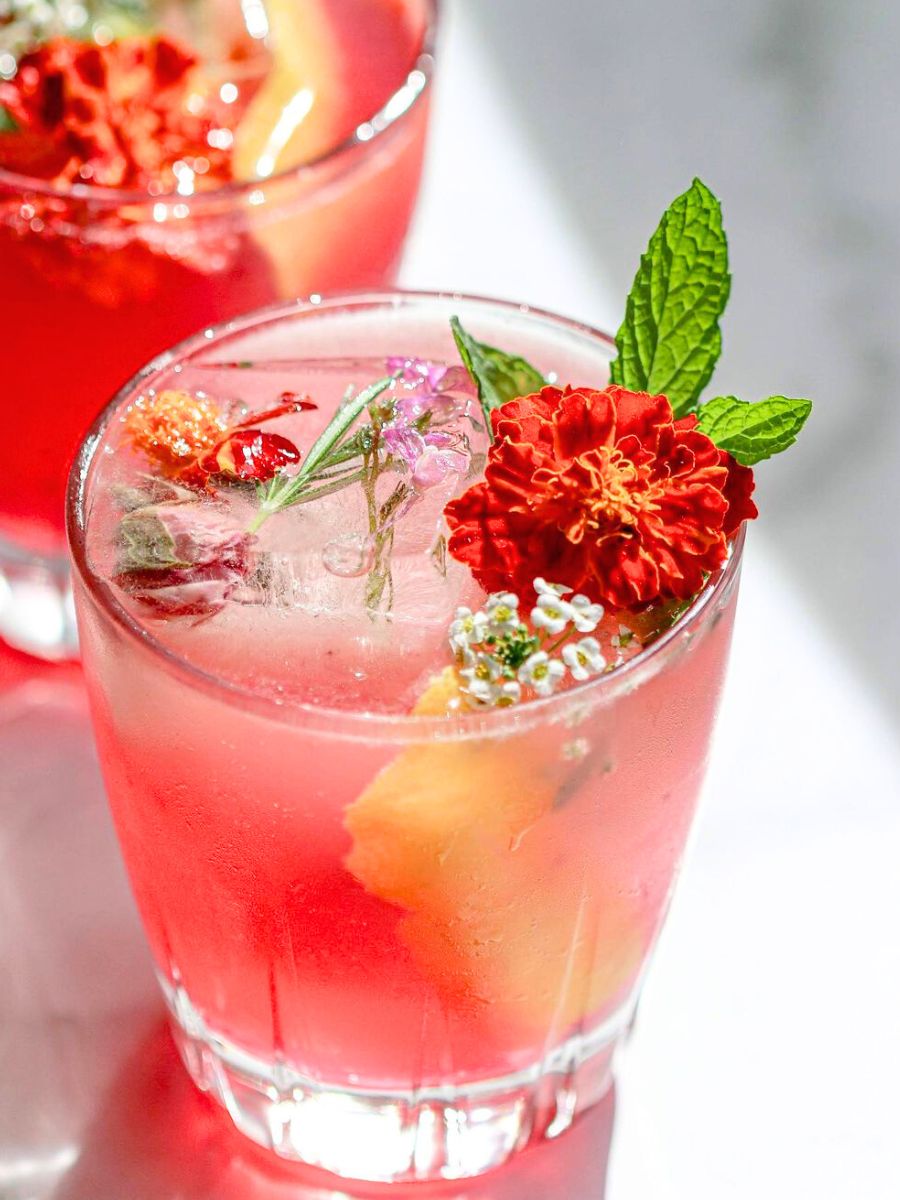 Cocktail with hibiscus syrup and flowers