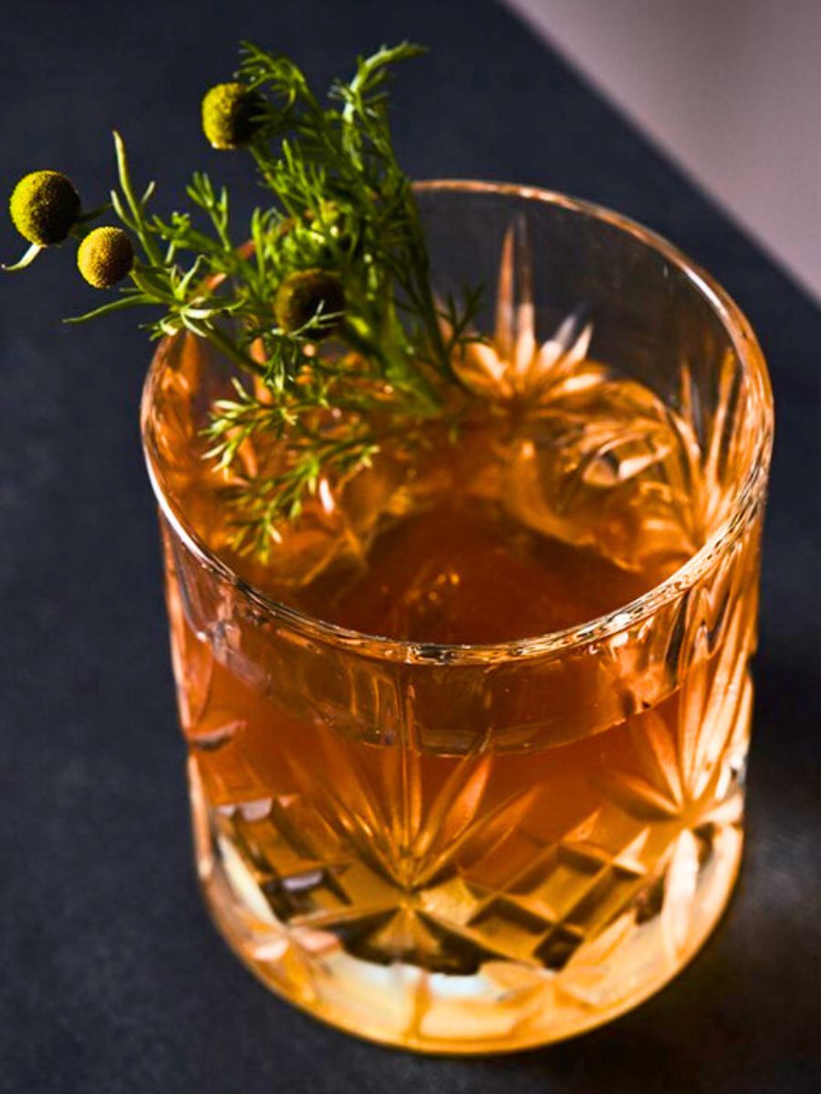 Whisky sour with chamomille herbs - edible flowers for drinks