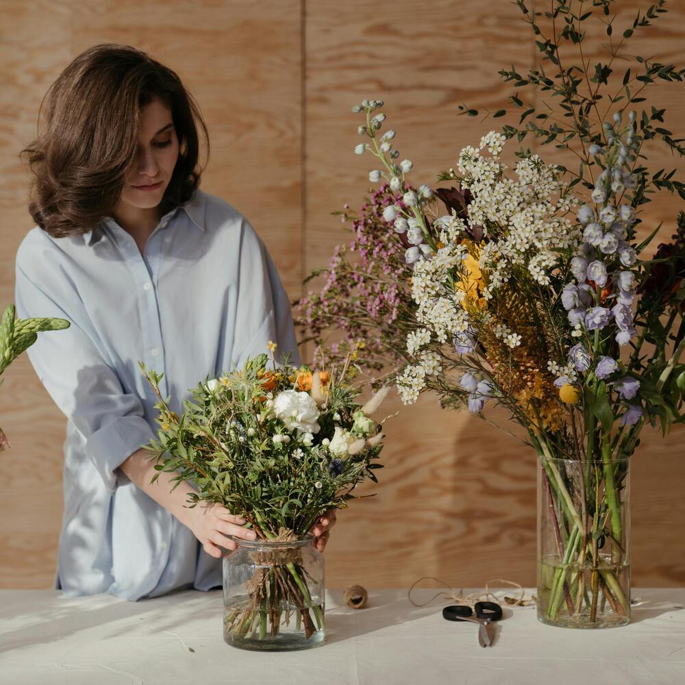 Lady arranging flower to create flower bouquet