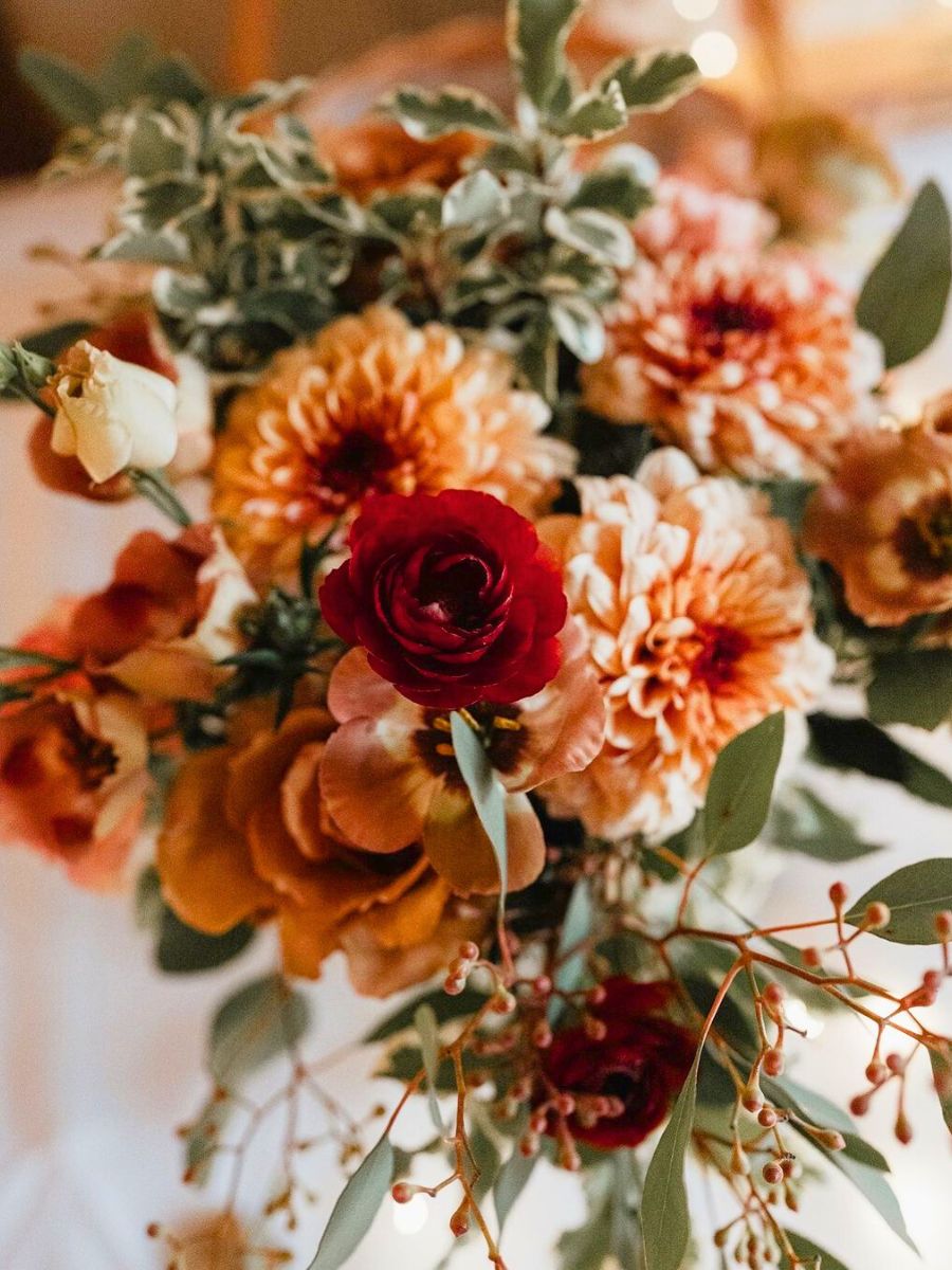 Red and orange floral arrangement by Fox and Bloom