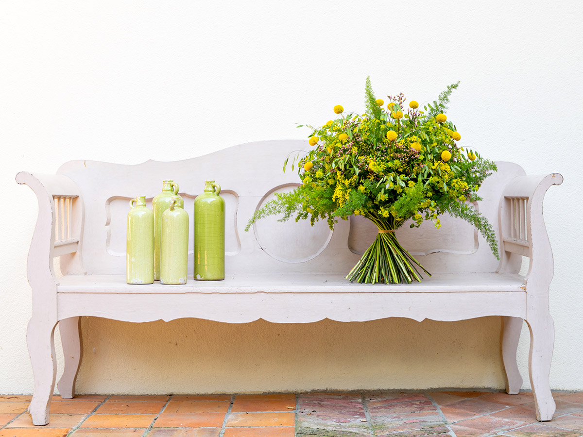 Krisztian Kover Craspedia bouquet on wooden bench