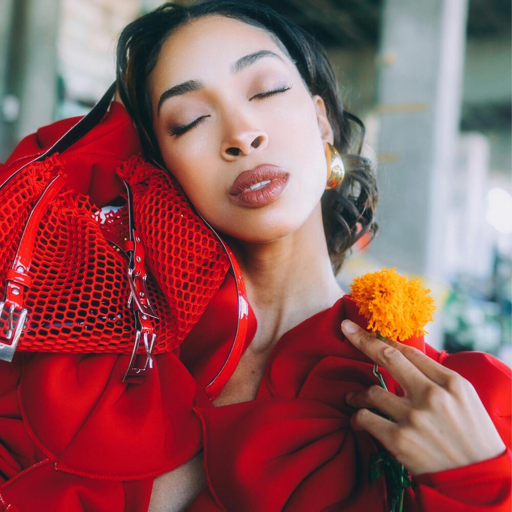 lady posing with orange flower 