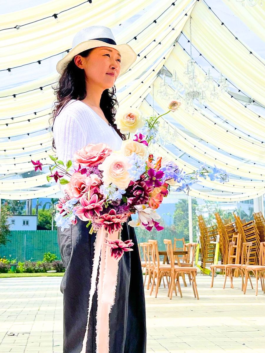 Jung Da Yoon holding a flower arrangement for an event