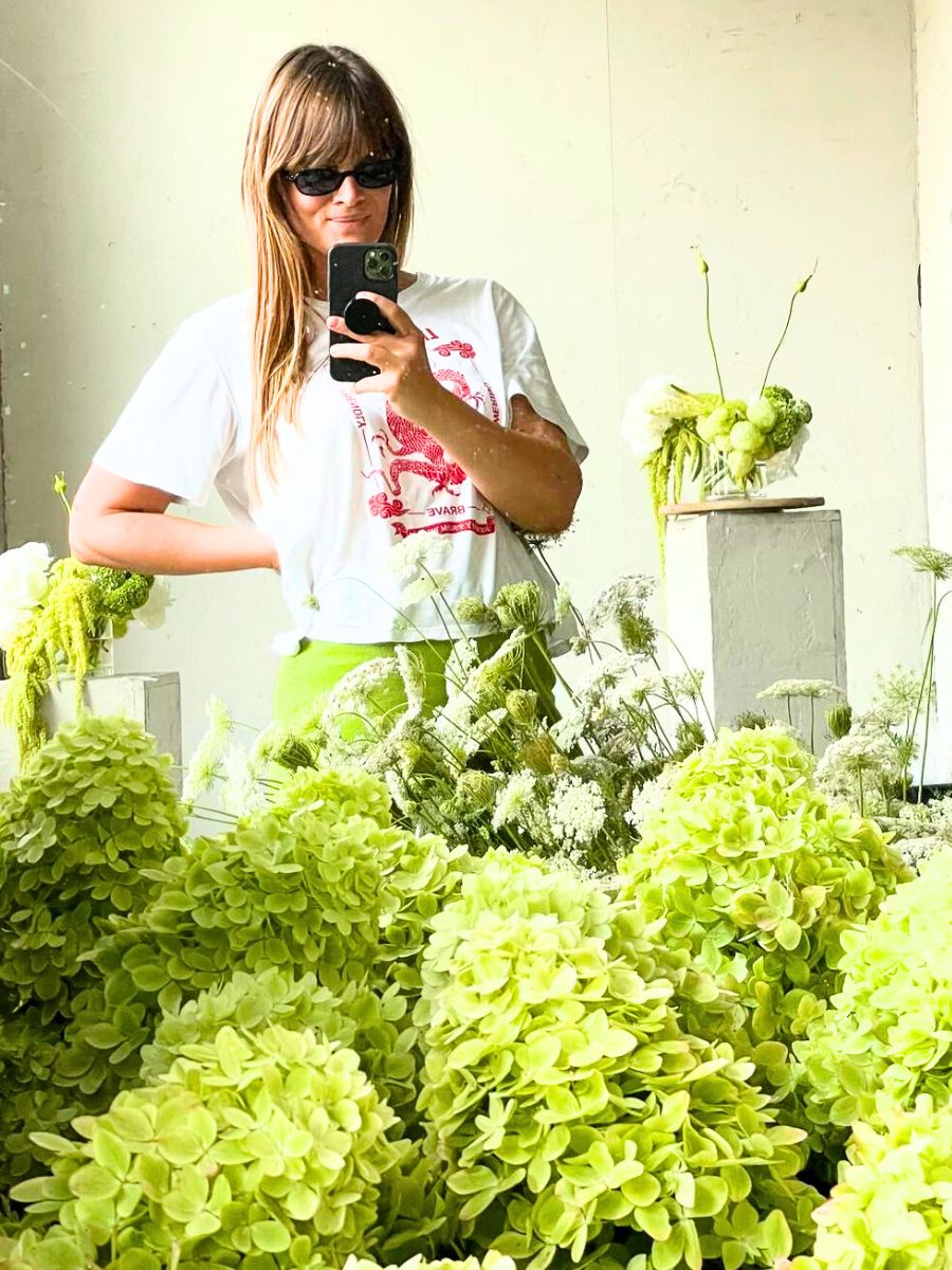 Leone among green hydrangeas and flowers