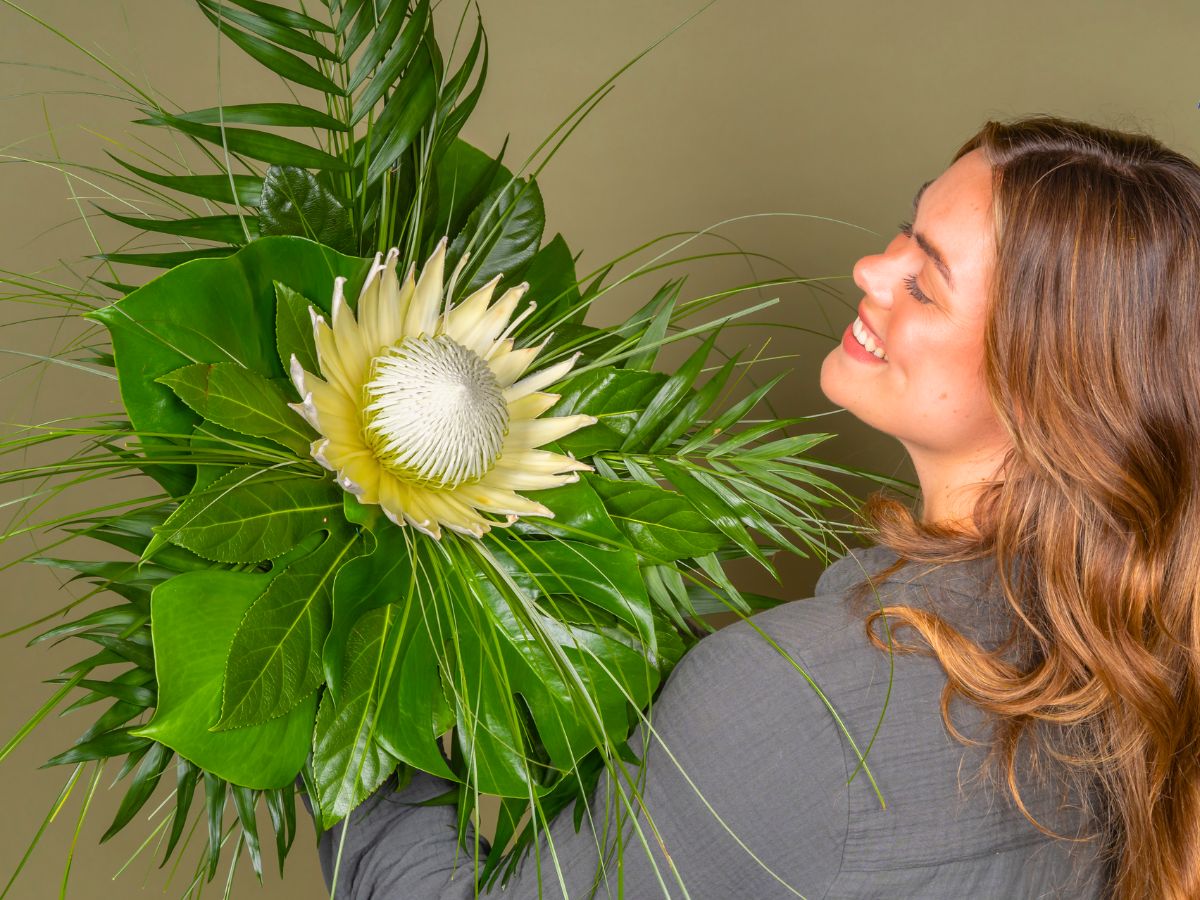 Girl with green foliage and protea