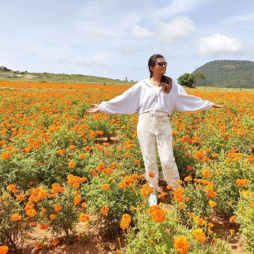 lady at Orange flower field on road trip to Karnataka