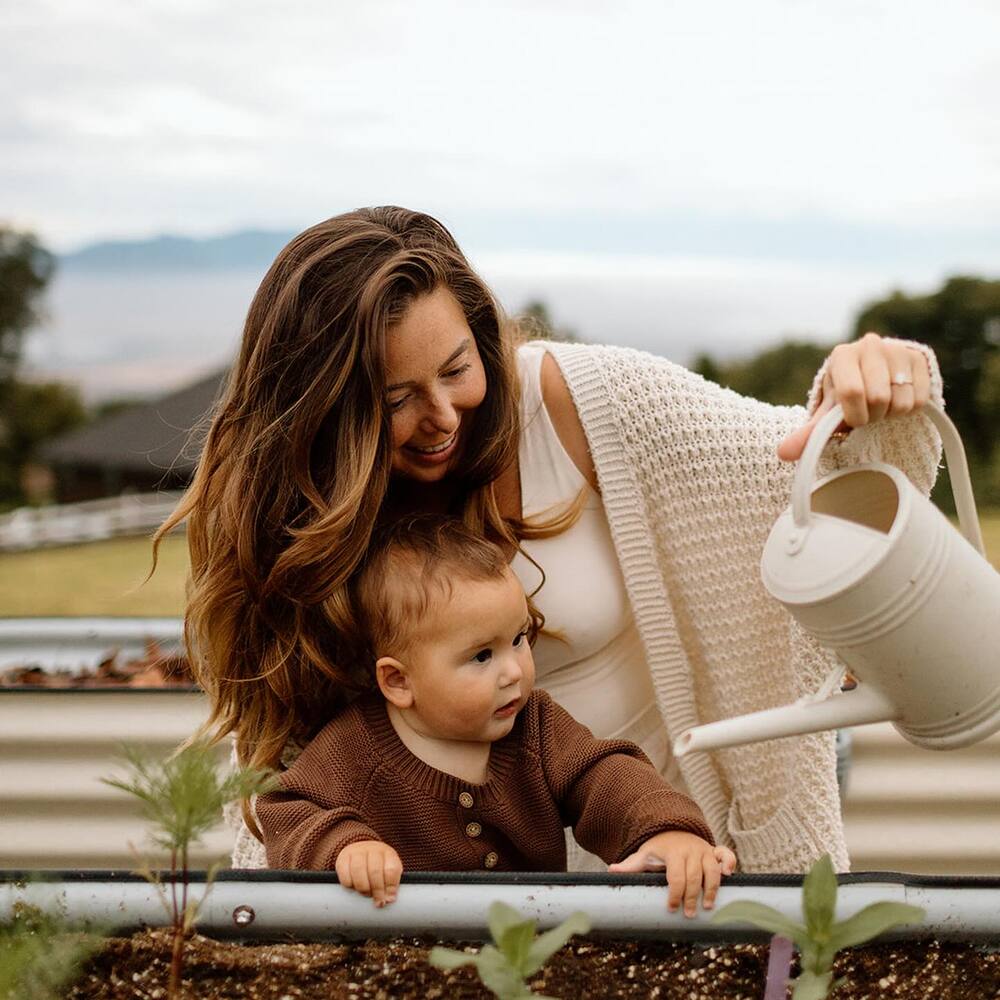 Lady with child watering to plant