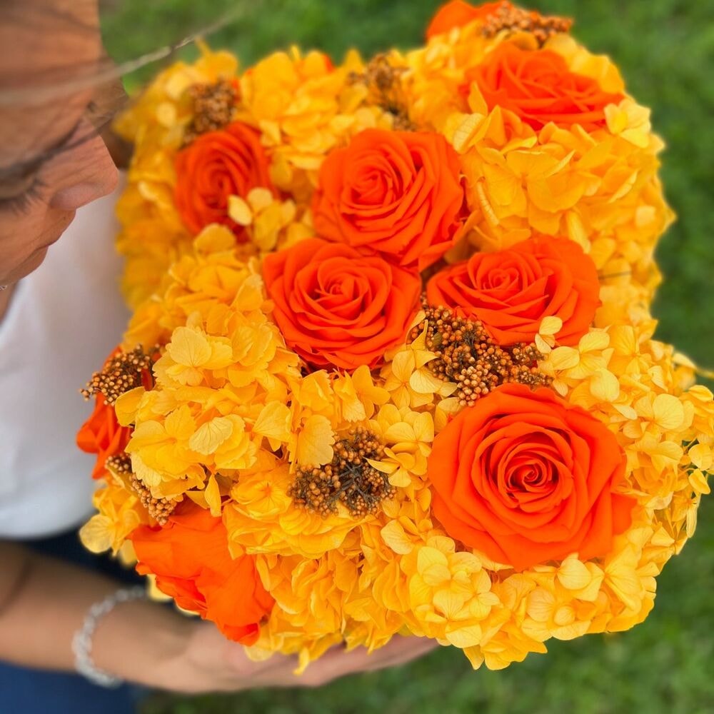 woman holding beautiful bouquet of flowers and preserved roses