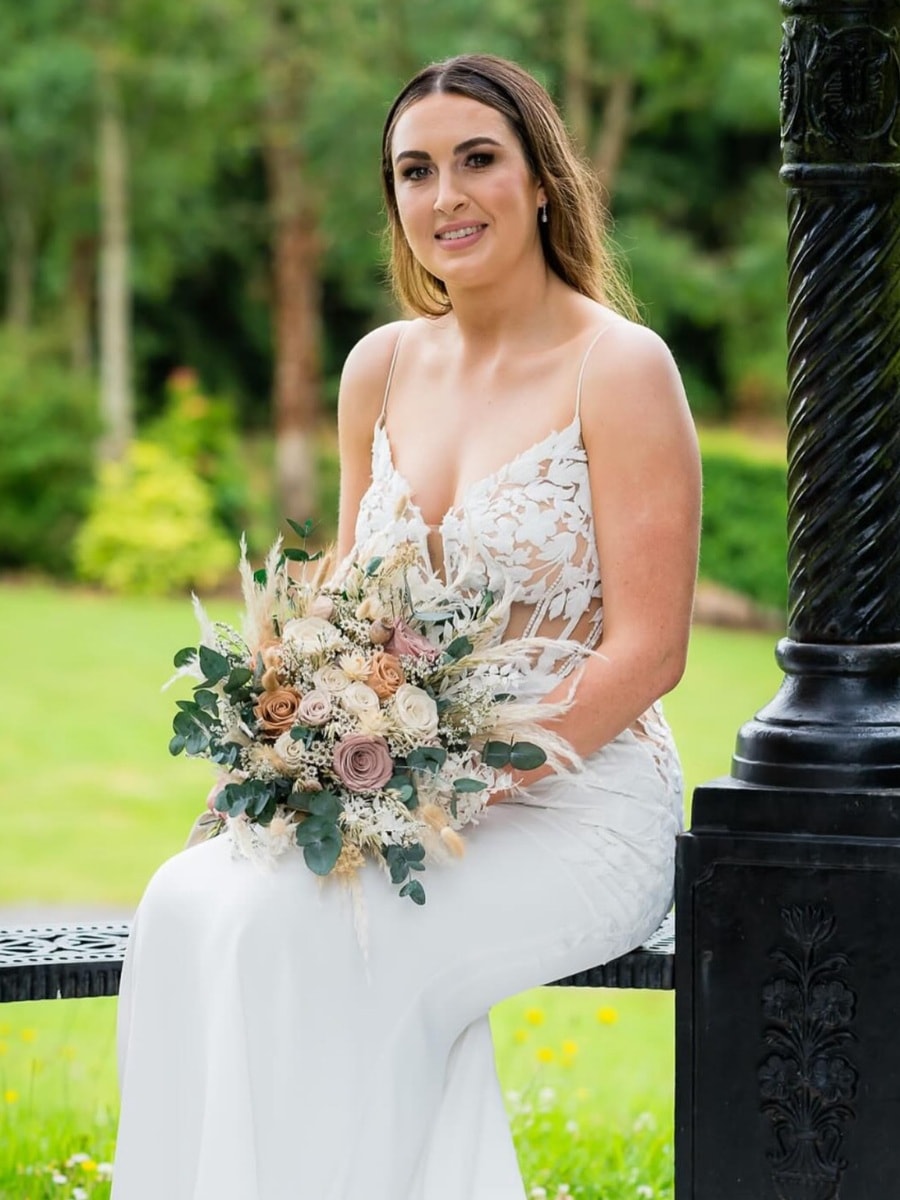 a bride holding a beautiful bouquet made of preserved roses and flowers