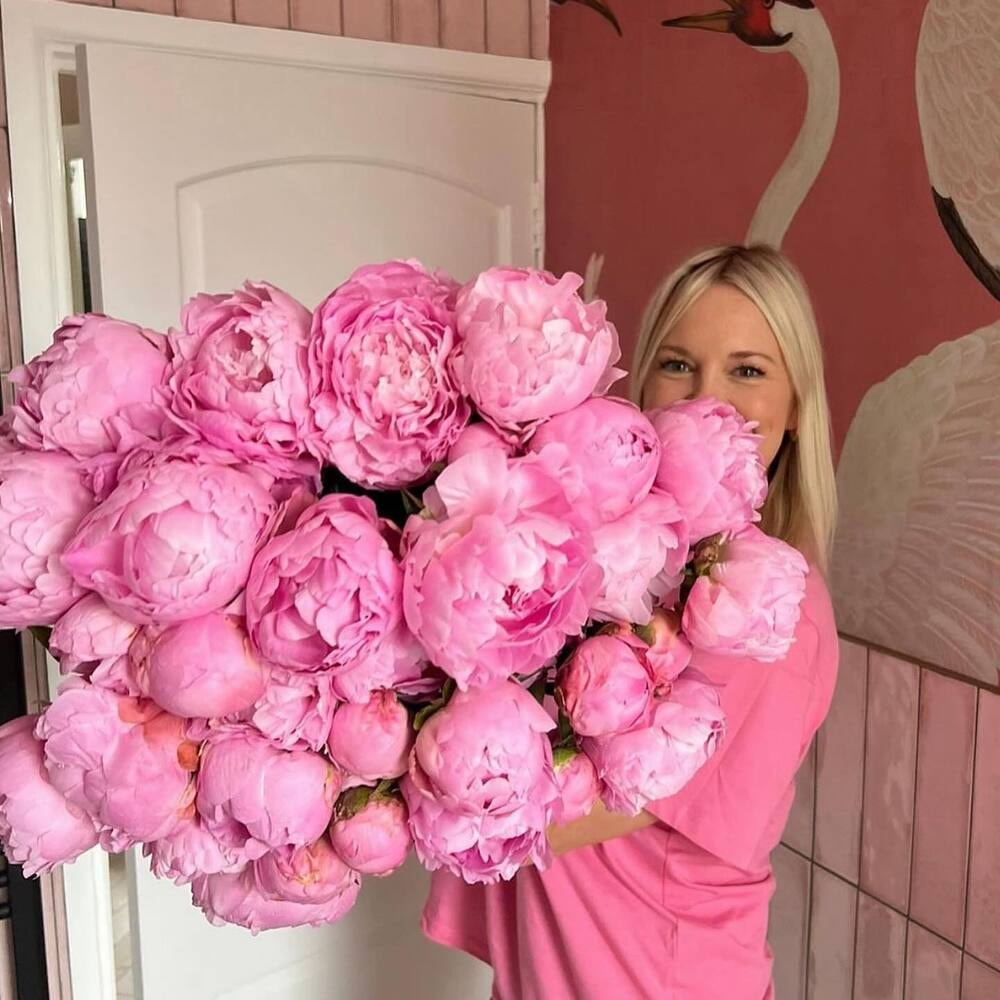 peonies flowers can grow as big as cabbages - woman holding large peonies