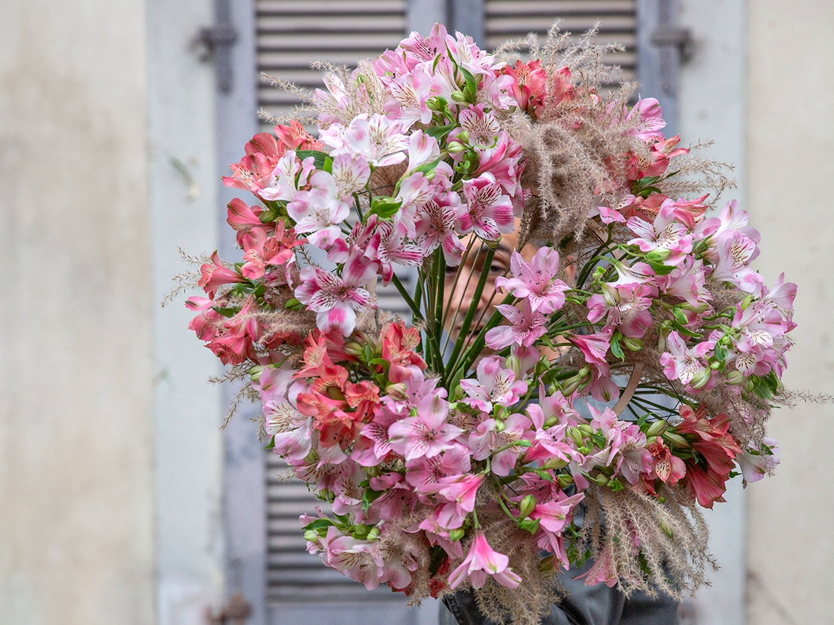 Dmitry Turcan posing with a bouquet made of Alstroemeria