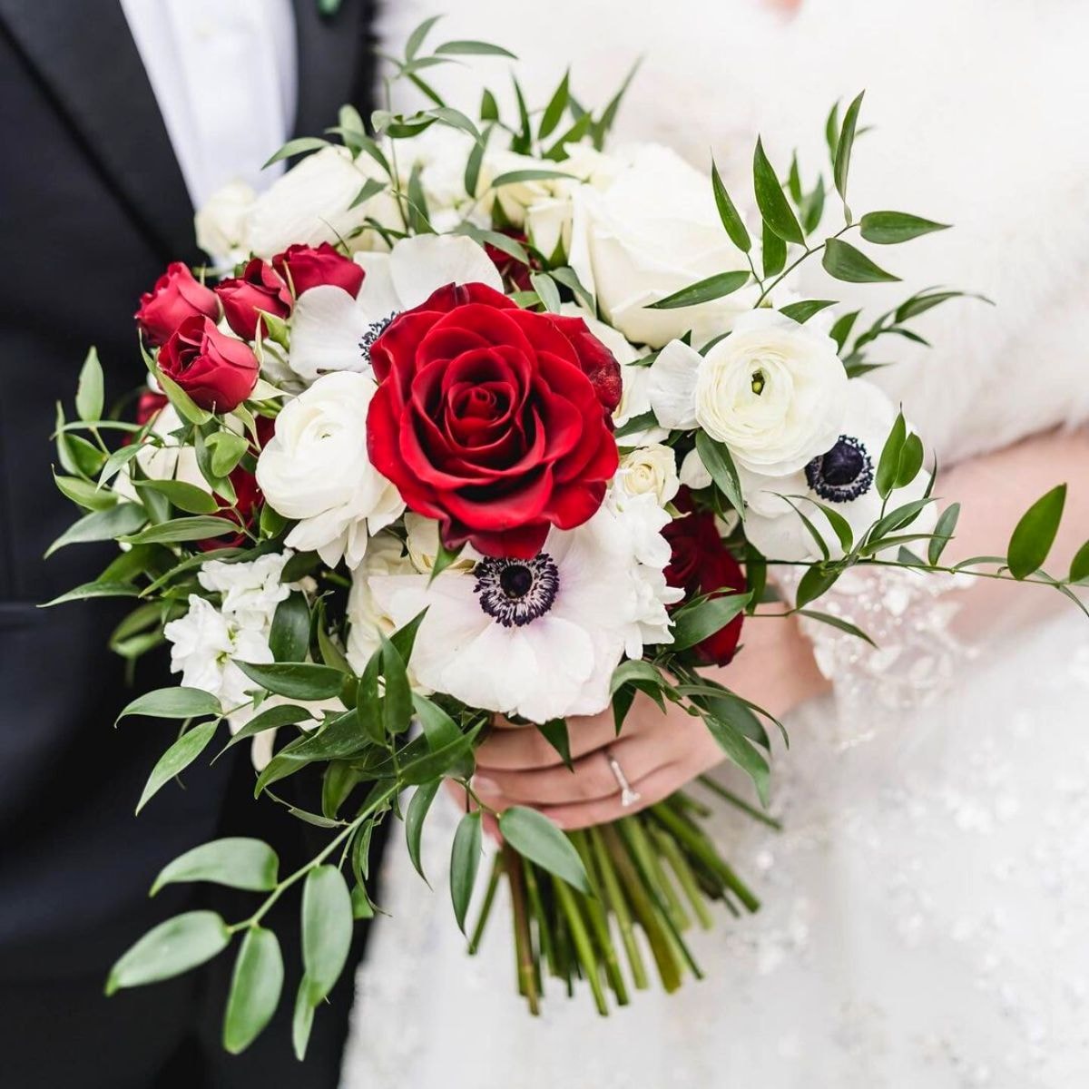 Fine match of white ranunculus and Panda anemones with red roses