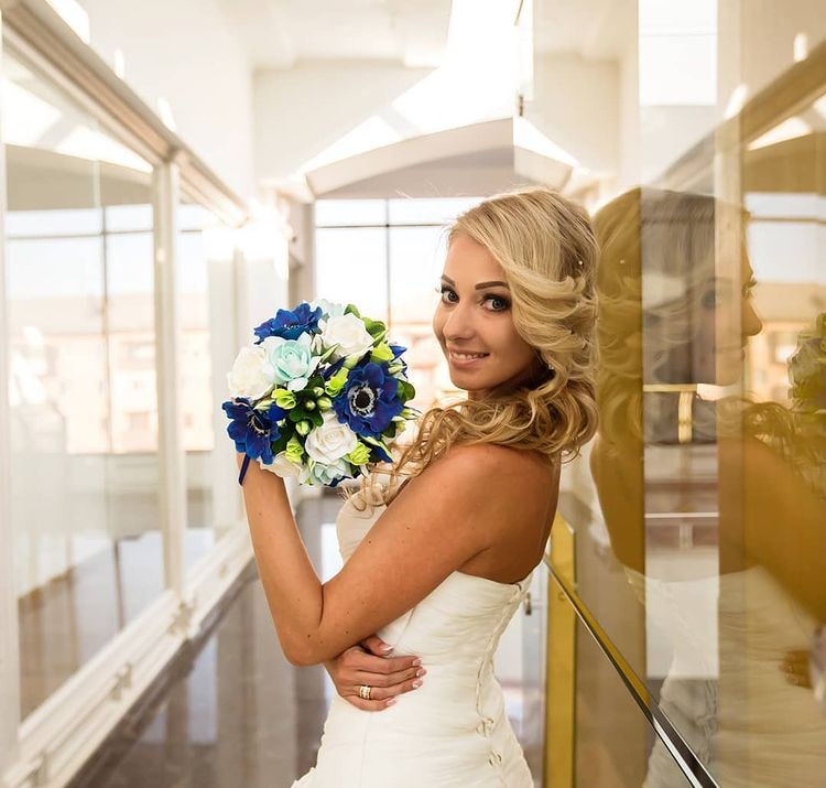 a bride holding a bouquet made of anemones