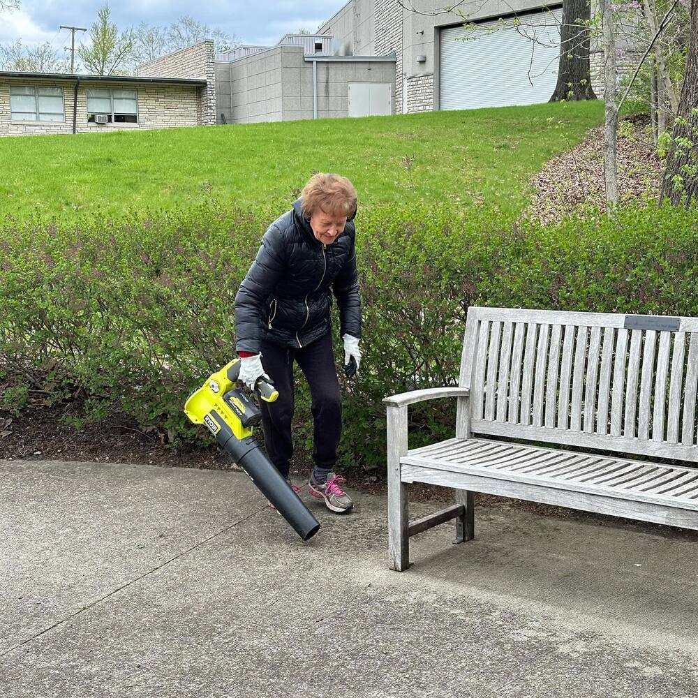 Old lady cleaning memorial garden