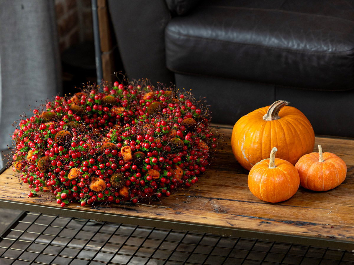 Krisztian Kover berries wreath and three pumpkins on table