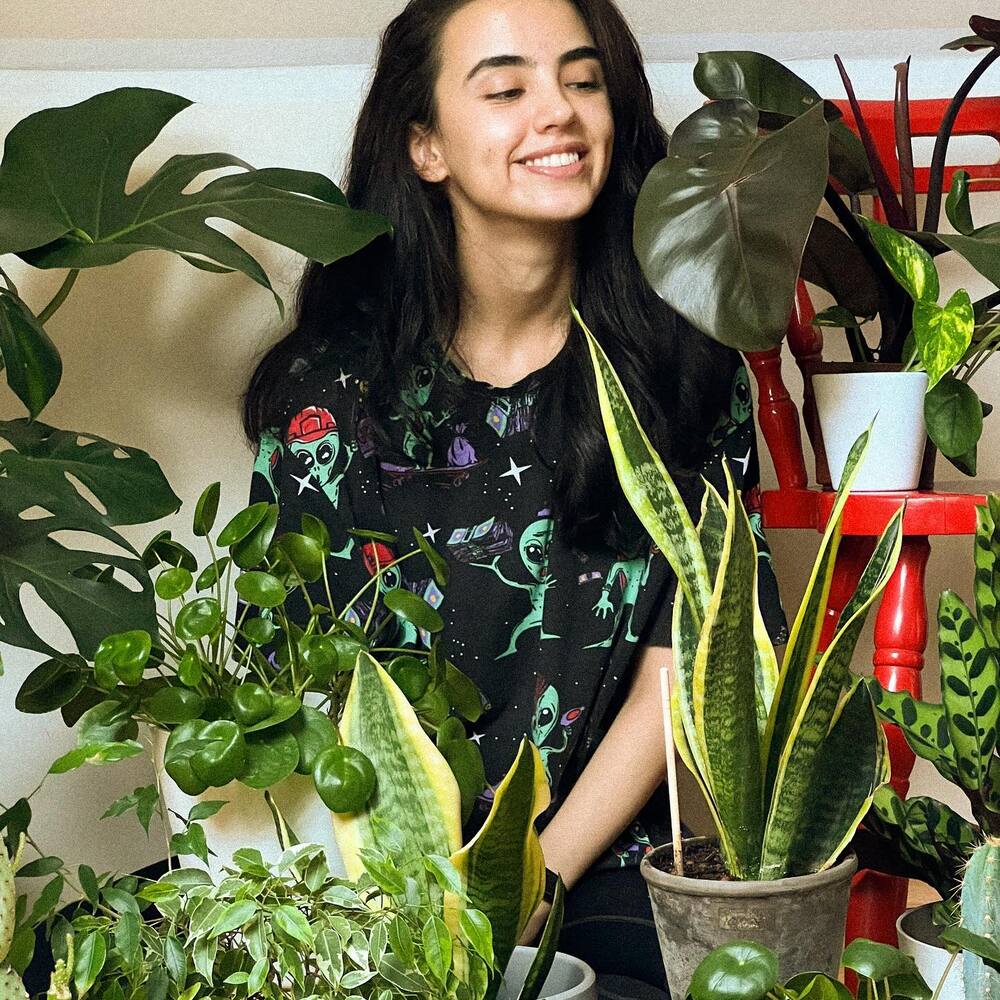 happy lady with green indoor plant