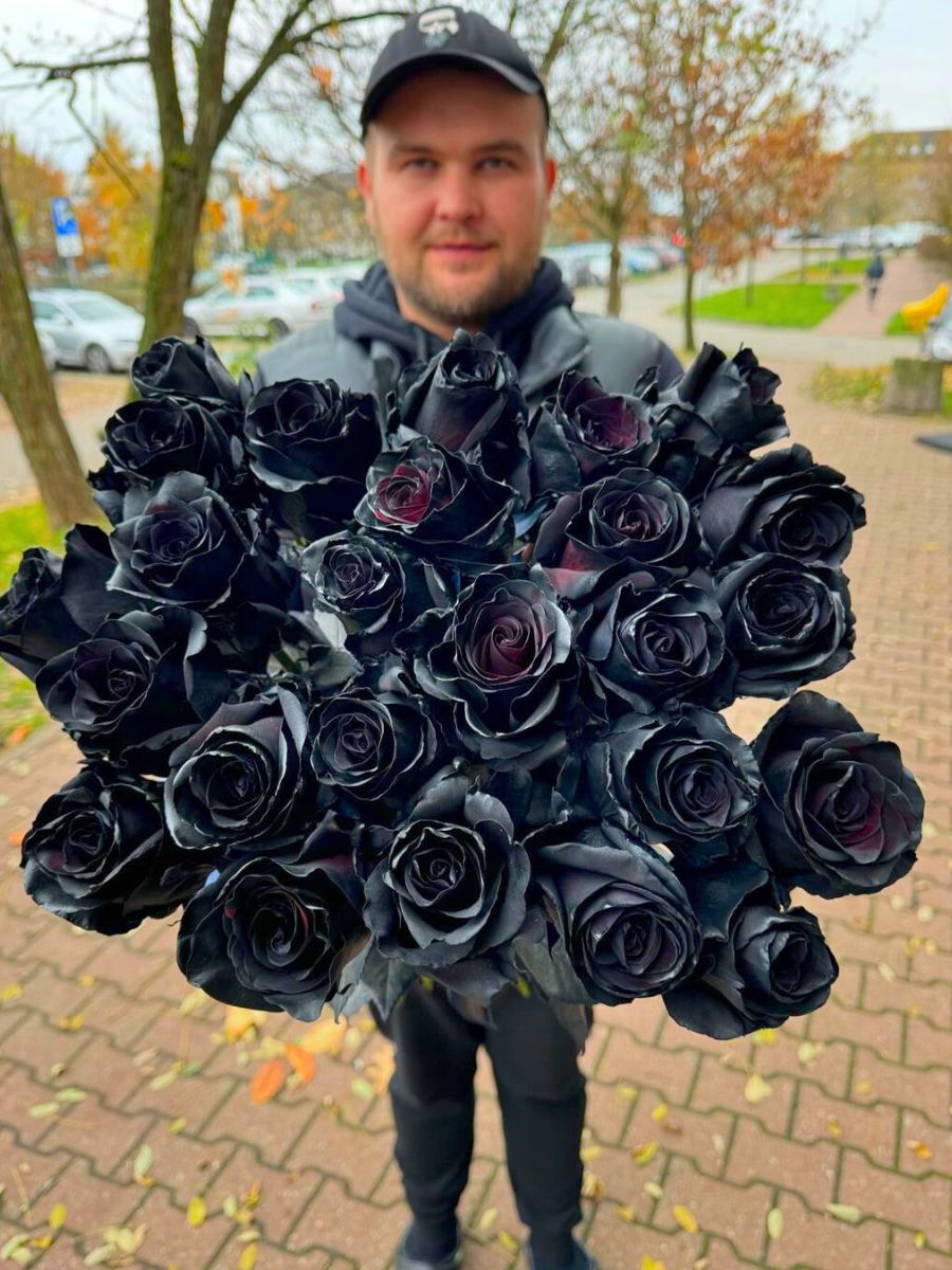 Guy holding a bunch of black tinted roses