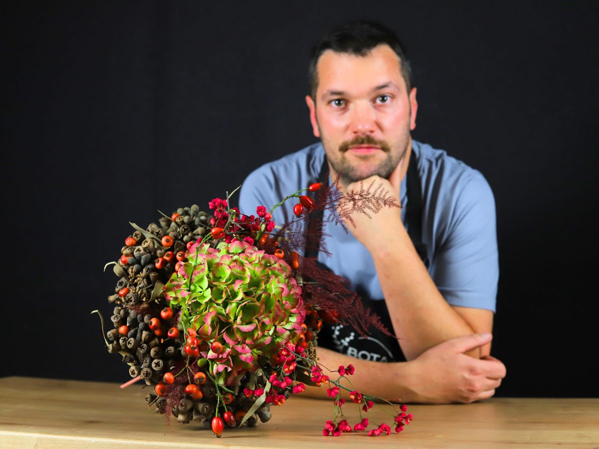 Gaetan Jacquet posing with a design with hydrangeas