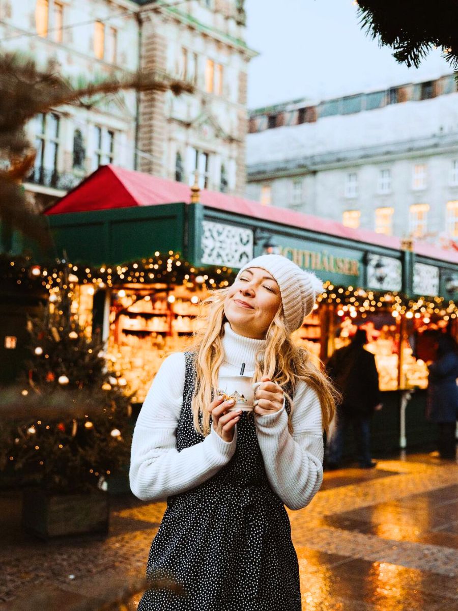 Girl drinking hot chocolate in a Xmas market