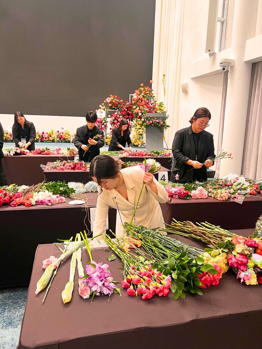 Students creating arrangements with Colombian flowers in Korean event