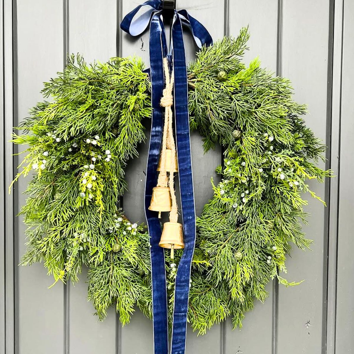 Juniper wreath with bells and blue ribbon