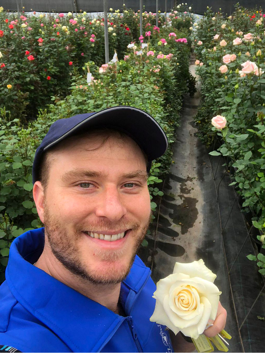 Aviram Krell with white rose  in Plantec greenhouse