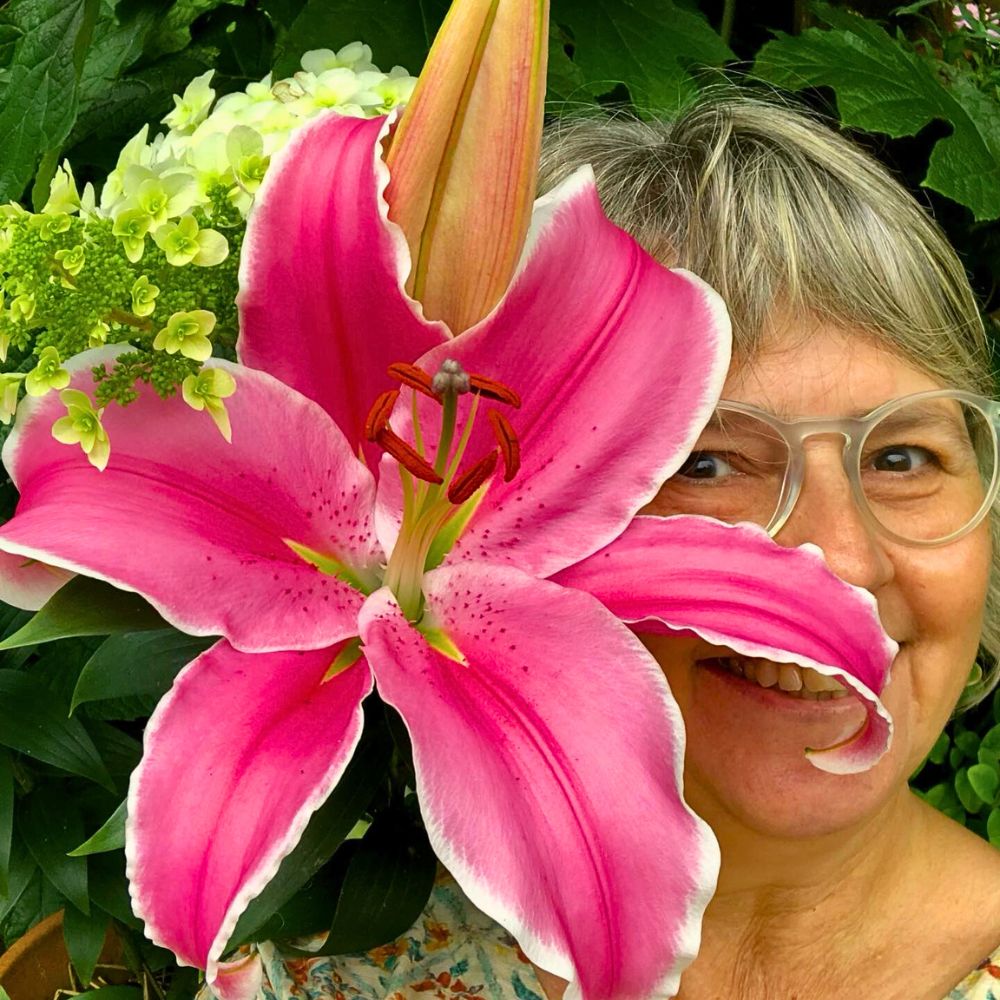 woman posing with a pink lily flower