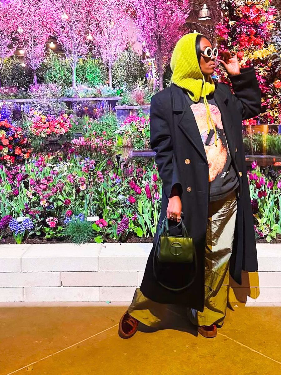 Visitor posing with floral background