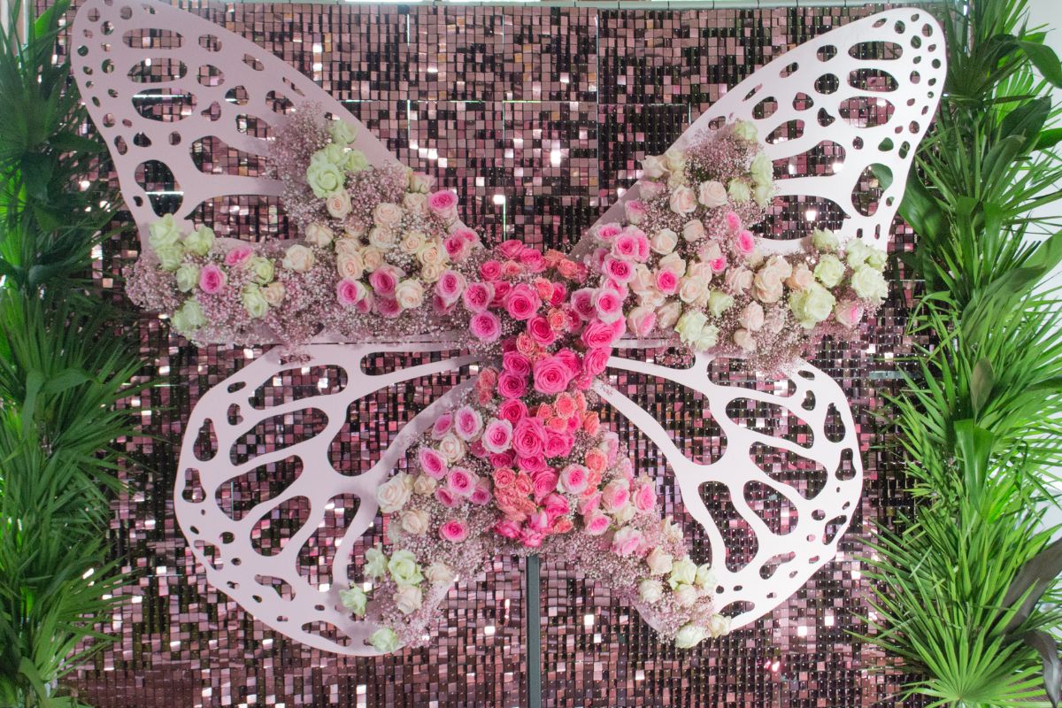 A Buttterfly With Glitter, Pink Roses and Lush Greenery