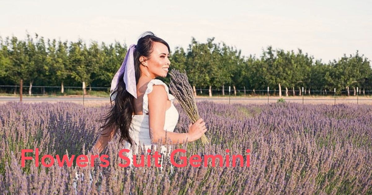 Woman enjoying fresh flowers in a green landscape.