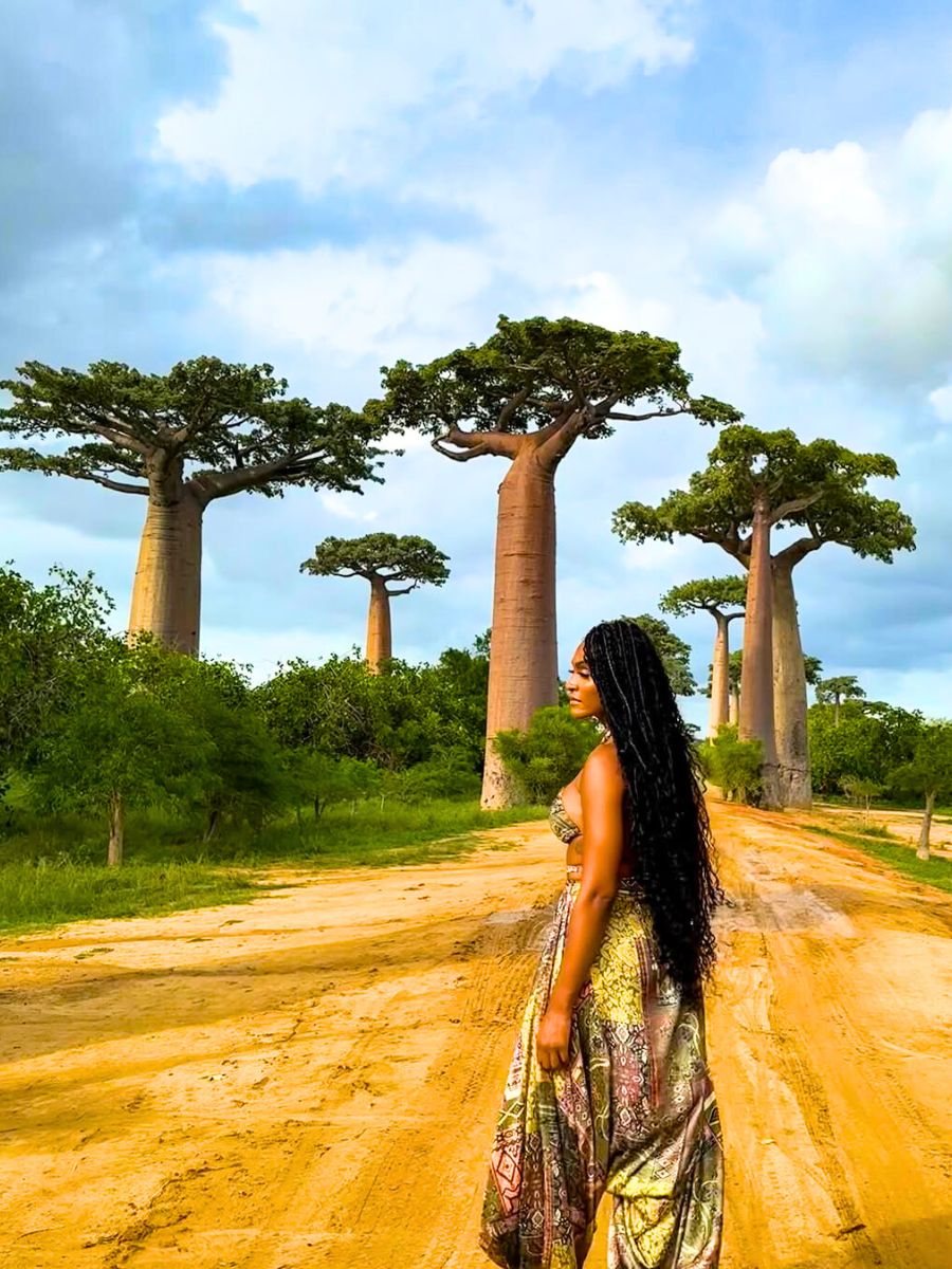 Woman in background of baobab trees