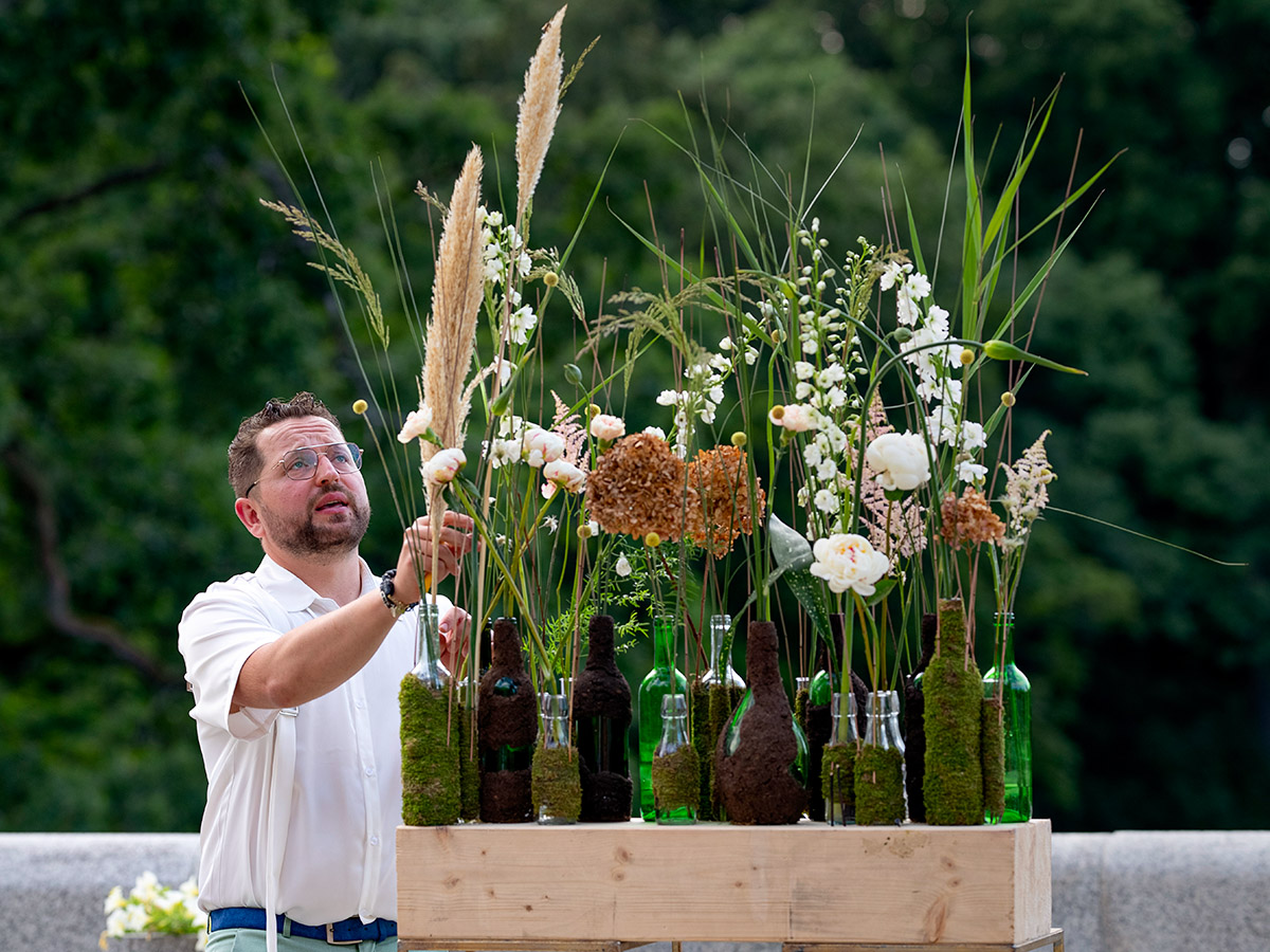 Max Kuczynski creating floral design with bottles