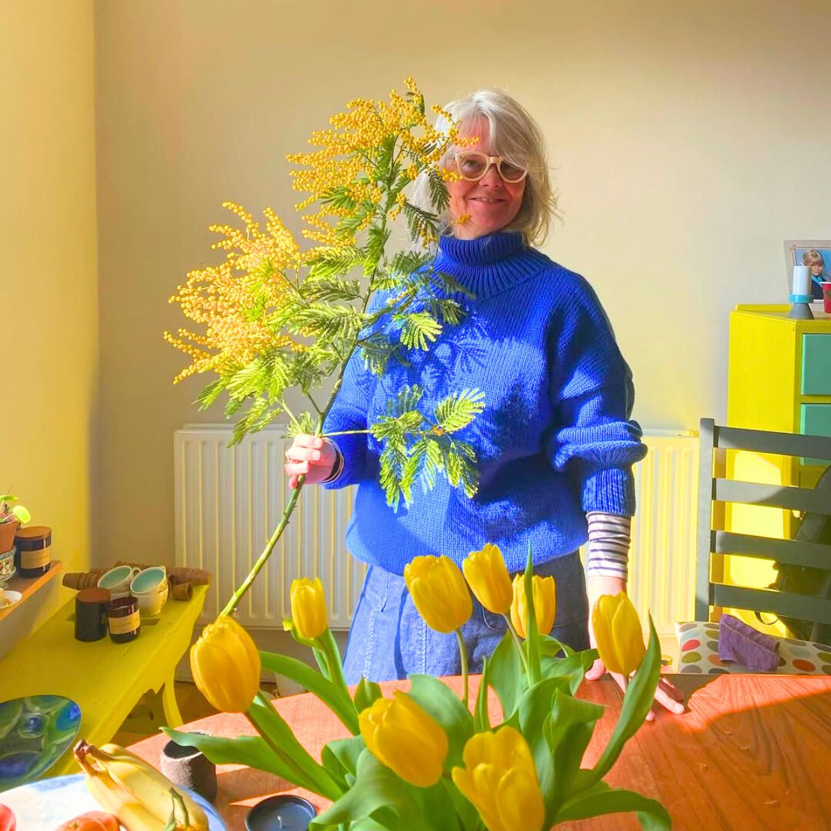 Woman with bright yellow mimosa flowers