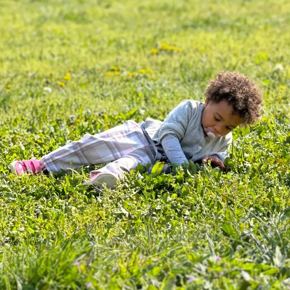 Kid playing over green space