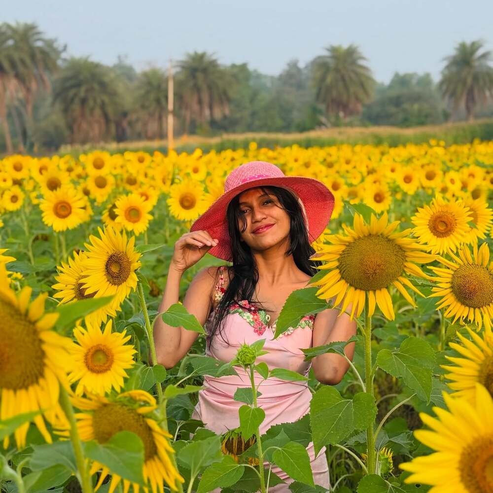 Woman in a pink hat among sunflowers  janhavinarke   