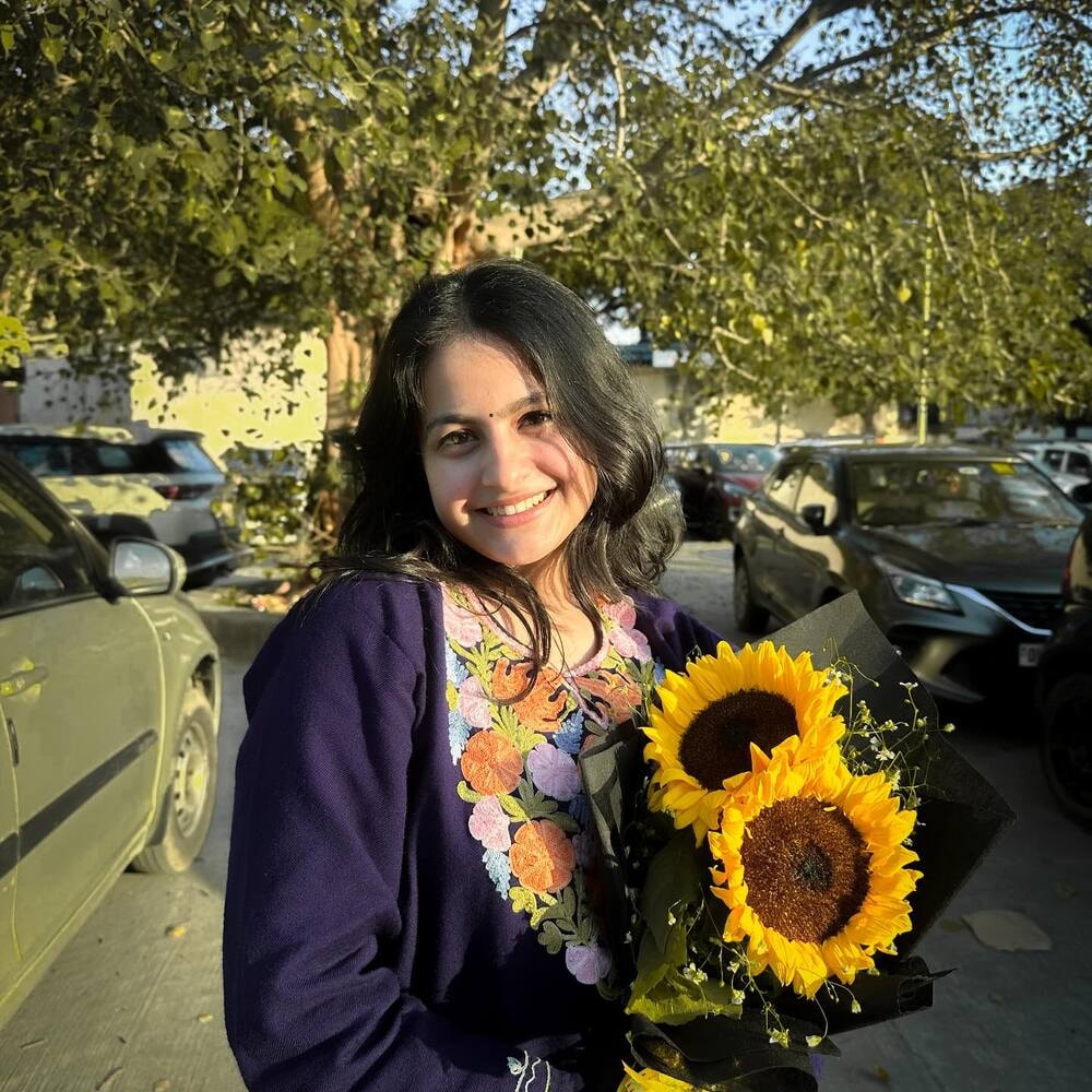 Smiling woman holding sunflowers outdoors