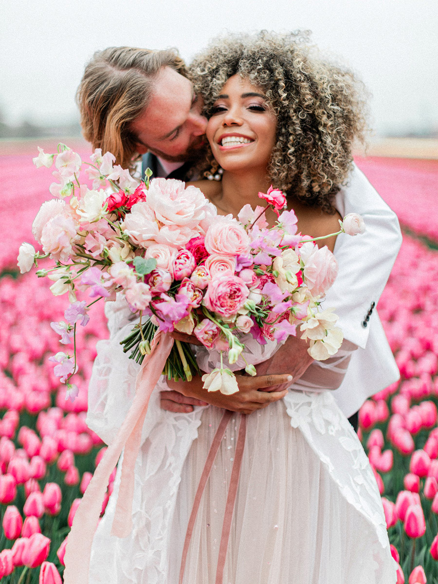 Katya Hutter bride and groom hug in pink tulip field