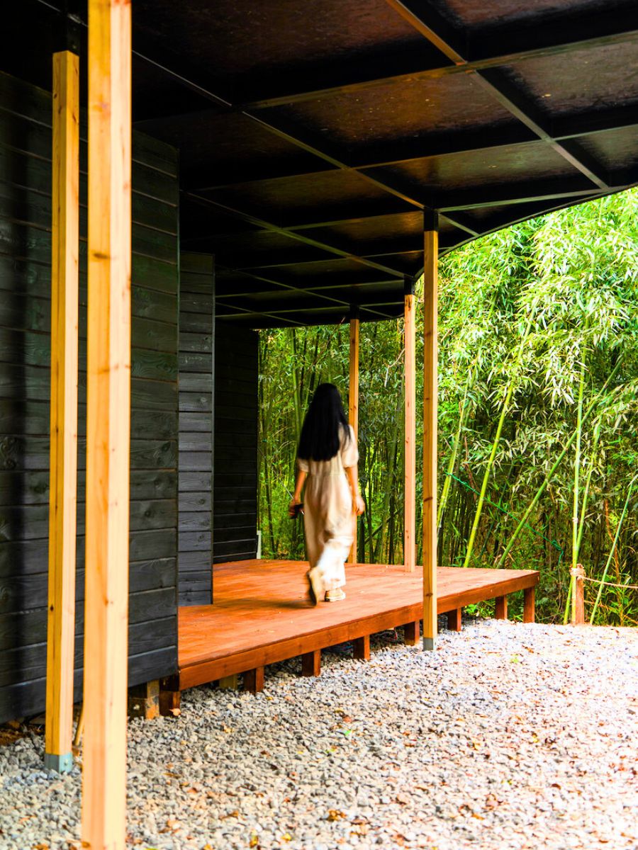 A black structured cabin with bamboo trees