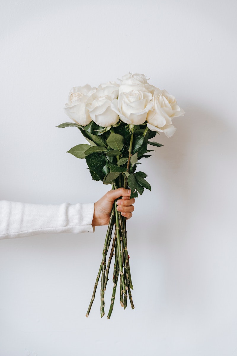someone holding a bunch of white roses