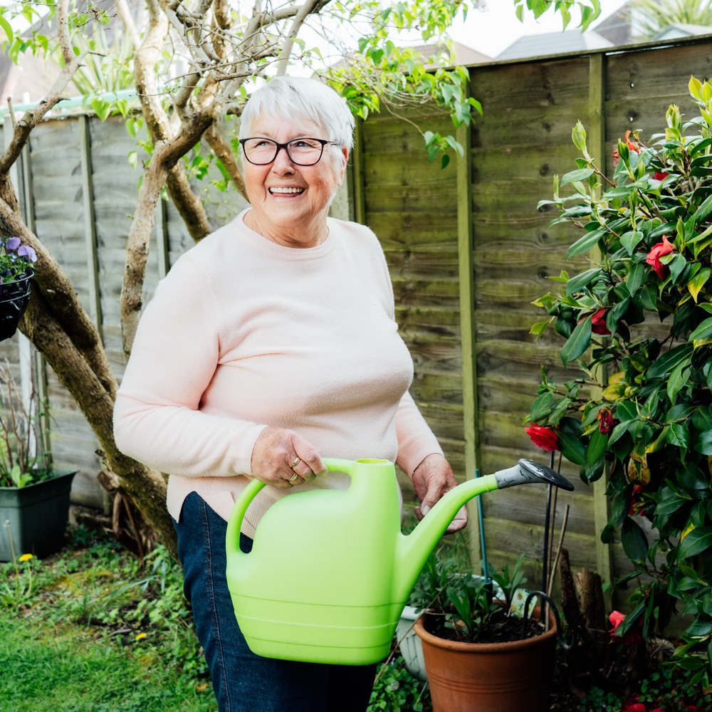 old lady watering to the plants