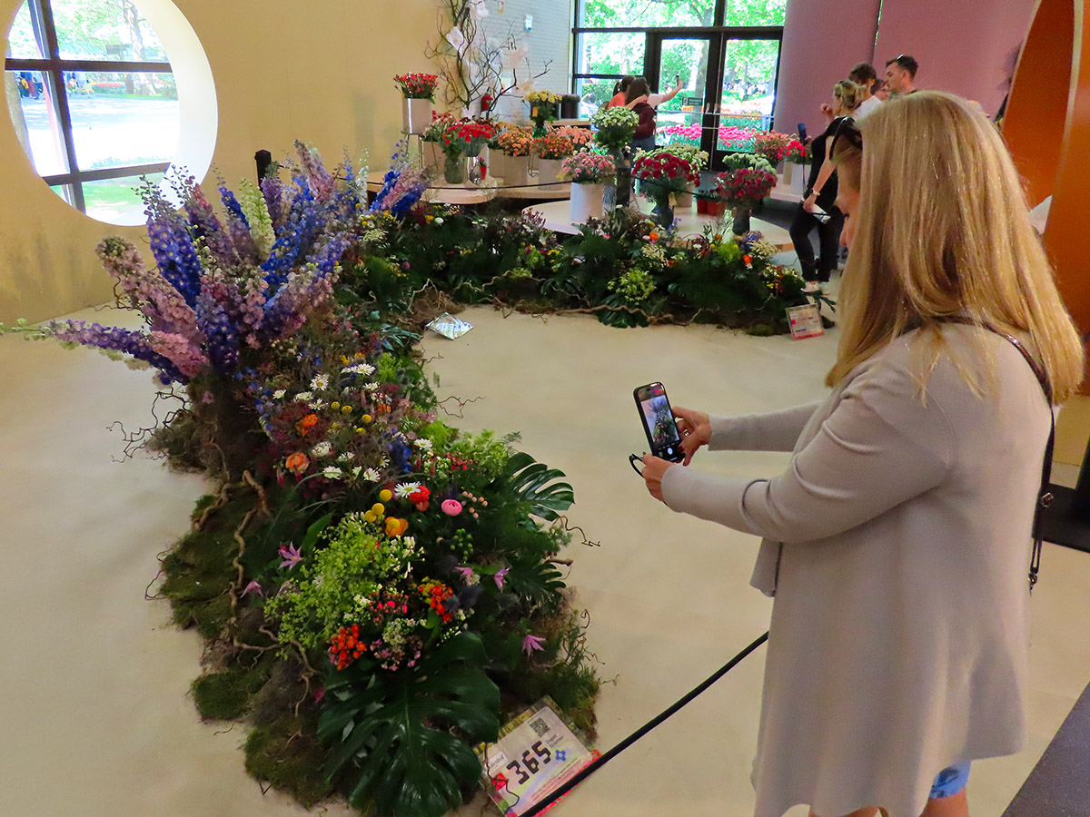 Woman photographing piece by 365 days of flowers Woman photographing piece by 365 days of flowers