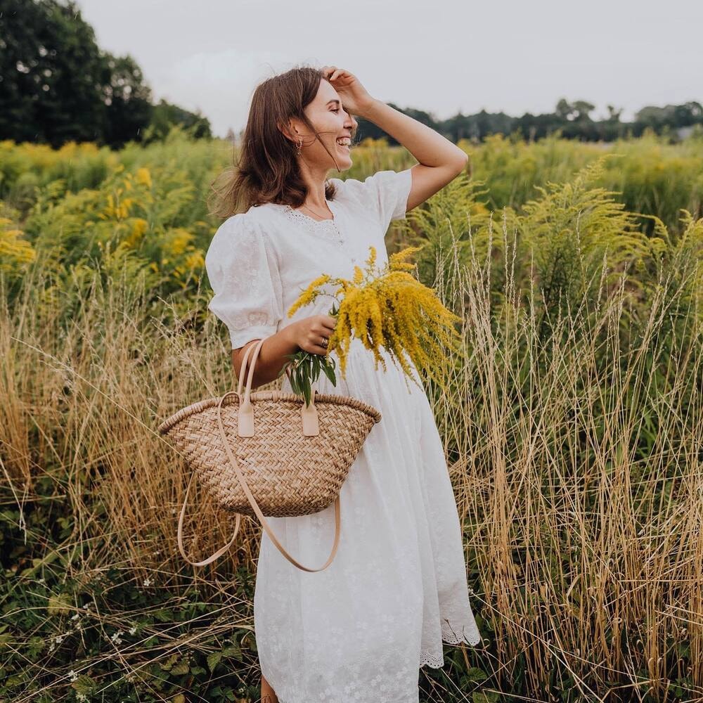 a woman holding a bunch of solidago flowers a woman holding a bunch of solidago flowers