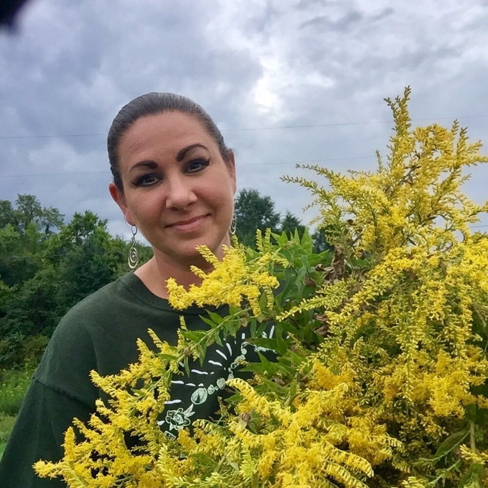 woman holding goldenrod plant woman holding goldenrod plant