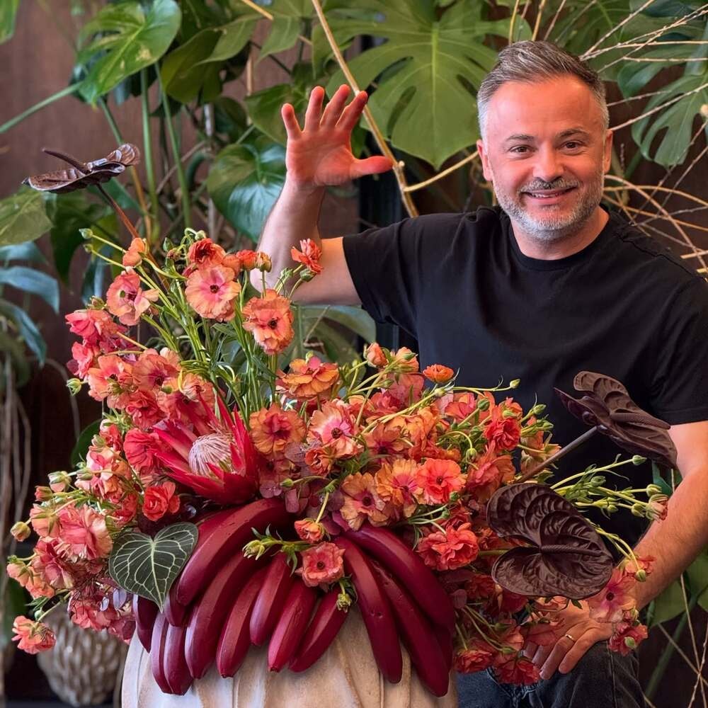 a florist posing with his floral design a florist posing with his floral design