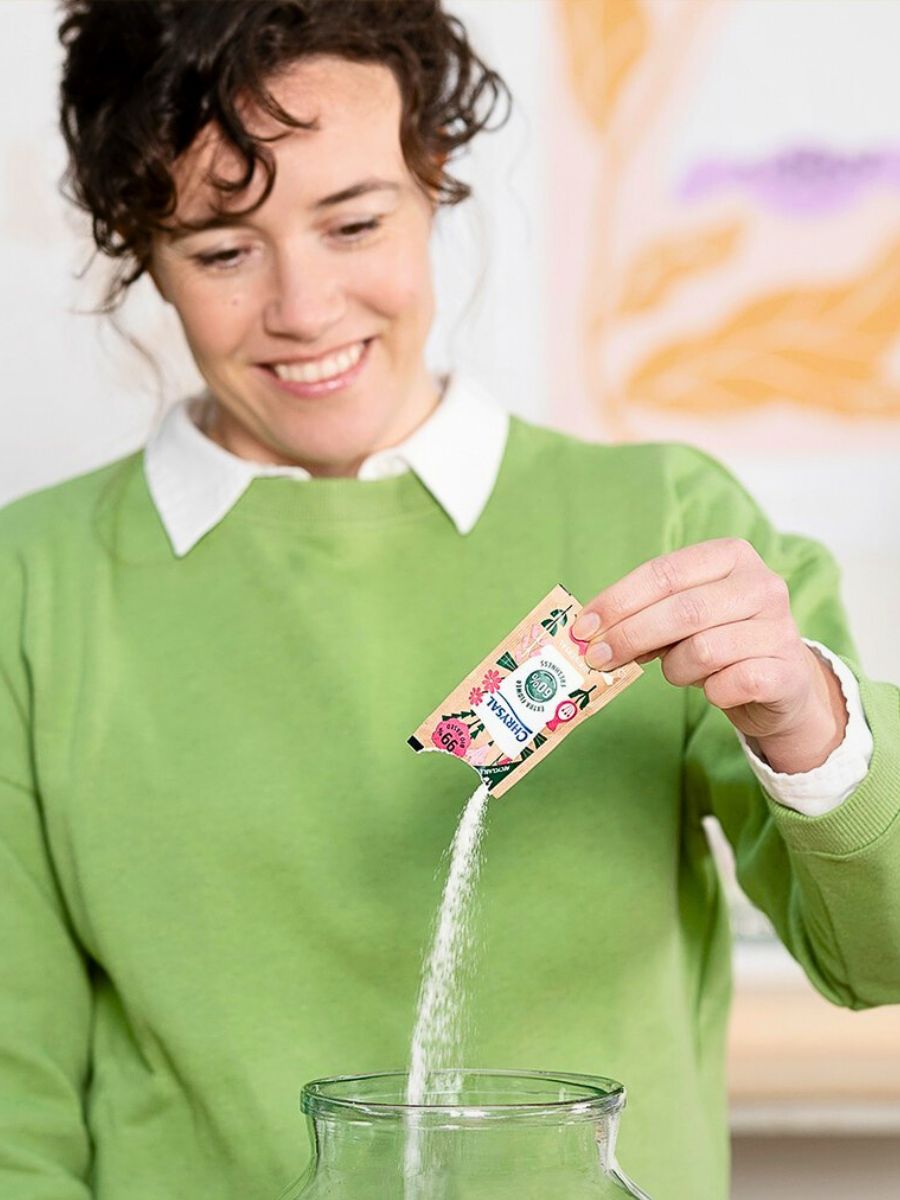 A lady with a pack of Chrysal flower food for cut flowers