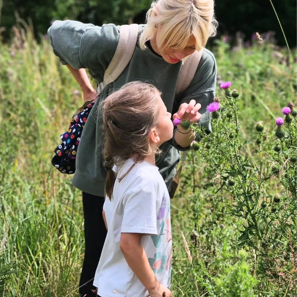 Admiring and smelling the Thistle flower Thistle flower meaning